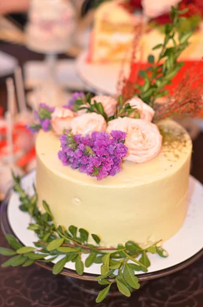 テーブルの上の花で飾られたウエディング ケーキ — ストック写真