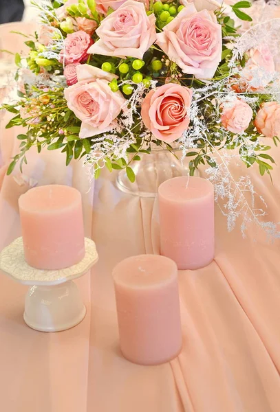 粉红色花朵和粉红色蜡烛在桌子上的花卉装饰 — 图库照片