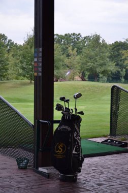 Yeşil çimen arka planda golf kulüpleri 