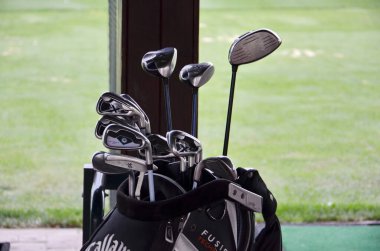 Yeşil çimen arka planda golf kulüpleri 