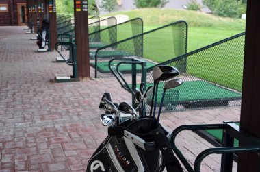 Yeşil çimen arka planda golf kulüpleri 