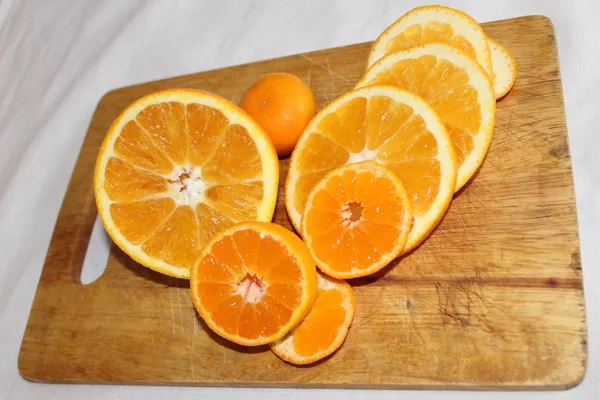 Μανταρίνι Και Πορτοκάλι Στο Διοικητικό Συμβούλιο Ένα Φόντο Πορτοκαλί Ζουμερό — Φωτογραφία Αρχείου