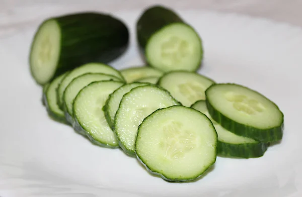 Beyaz arka plan üzerine bir tabak (güzel şekli) içinde salatalık dilimleri