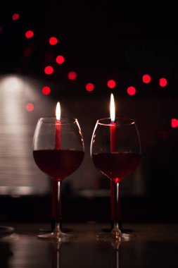 Romantik bir akşam yemeği: iki kadeh şarap ve candels çoğu karanlıkta arka yılbaşı ışıkları ile