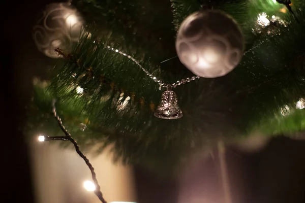 ぼやけた抽象的な暗い背景を持つクリスマスツリー上のライトとクリスマスのおもちゃ — ストック写真