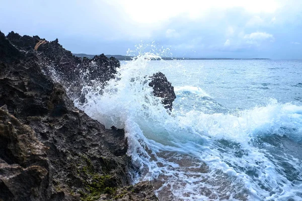 Deniz kenarındaki dalgalar fırtınalı bir günde kayalara sıçrıyor.