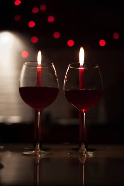 Romantik bir akşam yemeği: iki kadeh şarap ve candels çoğu karanlıkta arka yılbaşı ışıkları ile