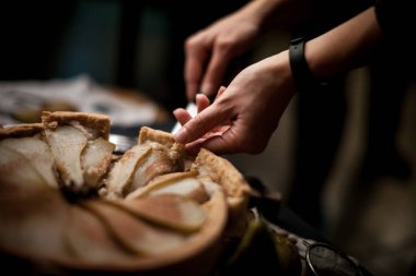 Meyve pasta kabuk. Şef'in el ile kesme bıçağı pasta kabuk bir rustik mutfak masasında dilimlenmiş.