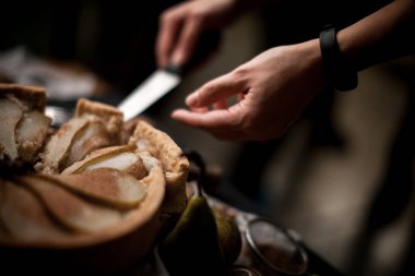 Meyve pasta kabuk. Şef'in el ile kesme bıçağı pasta kabuk bir rustik mutfak masasında dilimlenmiş.