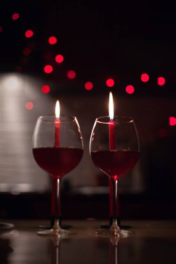 Romantik bir akşam yemeği: iki kadeh şarap ve candels çoğu karanlıkta arka yılbaşı ışıkları ile