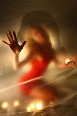 Mumları olan kız, polietilen 'in arkasında.