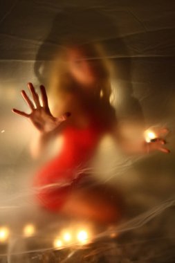 Mumları olan kız, polietilen 'in arkasında.