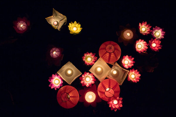 Плавающие бумажные фонари на воде ночью

