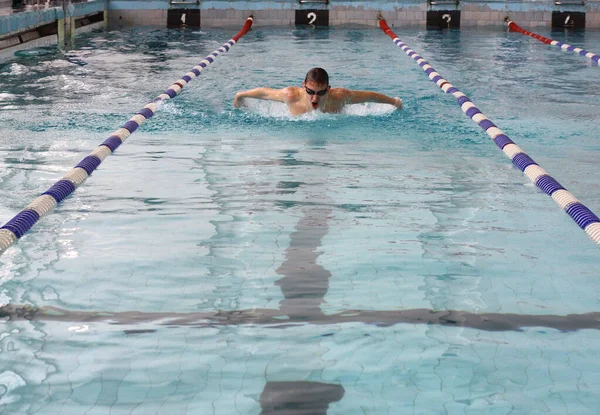 Nageur dynamique et ajusté dans la respiration du bonnet effectuant le coup de papillon. Compétition de natation entre les étudiants, à l'Université d'Etat de Samara le 27 avril 2009 — Photo