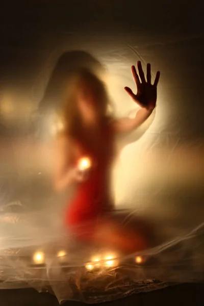 Mumları olan kız, polietilen 'in arkasında.