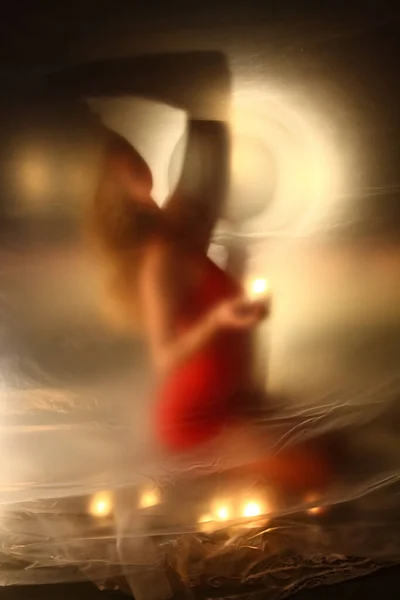 Дівчина зі свічками вогонь, за поліетиленом — стокове фото