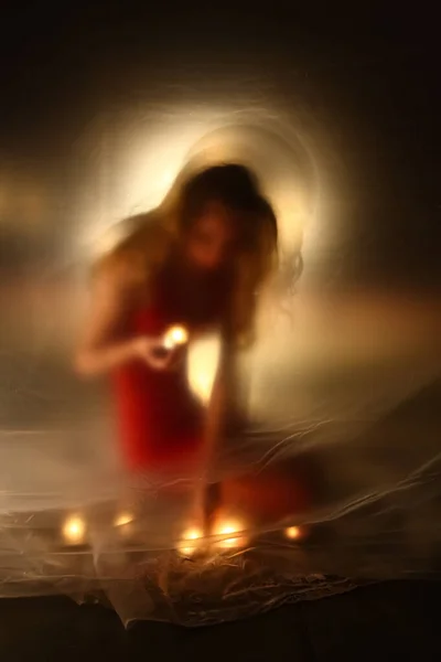 The girl with candles fire, behind the polyethylene — Stockfoto