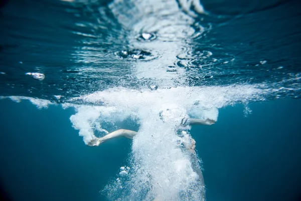 Erkekler köpüklü mavi suya atlarlar.