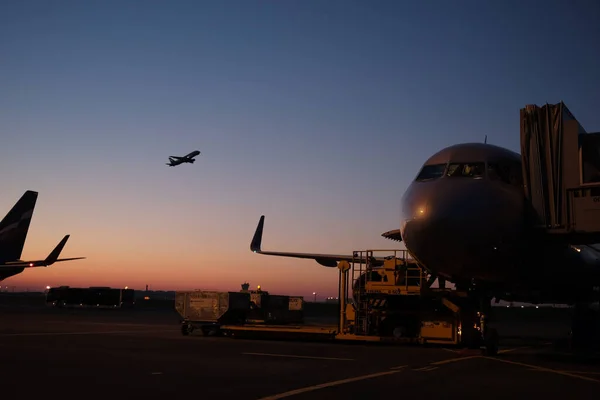 Avión en el aire y otro avión y puesta de sol en el fondo — Foto de Stock