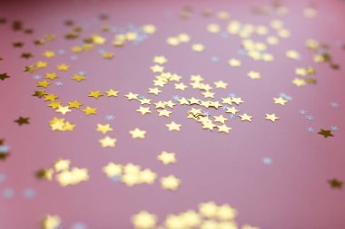 Yıldızlar ve kar taneleri pembe arka planda, yukarıdan