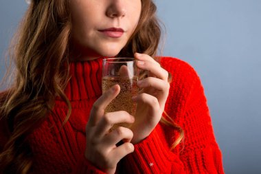 Partide kadın eli kokteyle yakın durun. Kırmızı elbiseli kız.