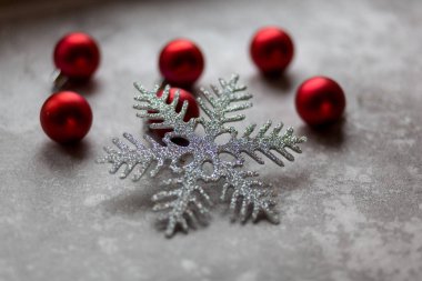 Gri bir arka planda Noel süslemeleri. Gümüş bir kar tanesi