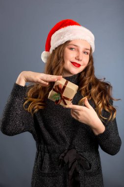 Beyaz bir kadın gri arka planda bir hediye tutuyor. izol