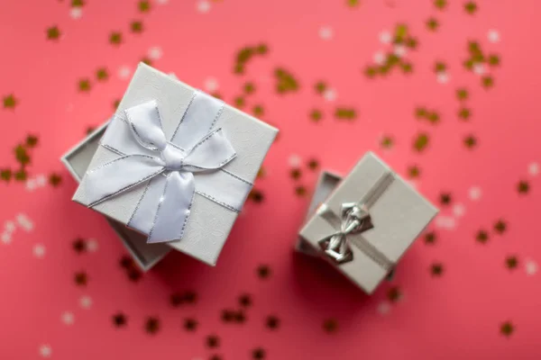 Weiße strukturierte Geschenkboxen mit Schleifen, umgeben von Sternen und — Stockfoto