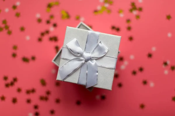 Білі текстуровані подарункові коробки зі стрічковими бантами в оточенні зірок — стокове фото