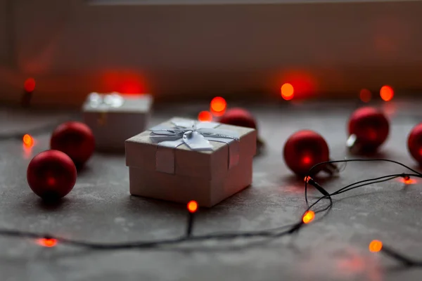 Decoraciones navideñas sobre un fondo gris. Un blanco con un lazo i —  Fotos de Stock