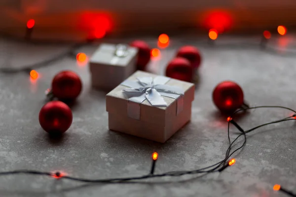 Decoraciones navideñas sobre un fondo gris. Un blanco con un lazo i —  Fotos de Stock