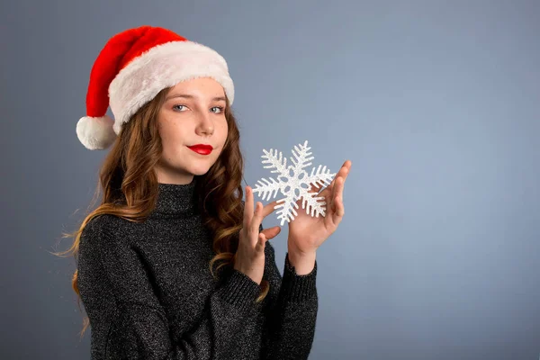 Chica en santa hat retrato con gran plata copo de nieve juguete posando —  Fotos de Stock