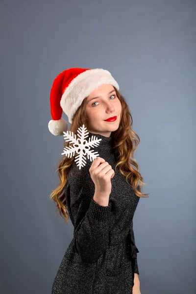 Chica en santa hat retrato con gran plata copo de nieve juguete posando — Foto de Stock