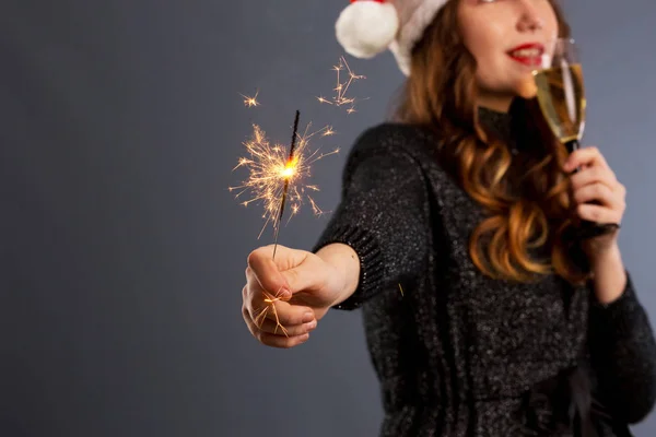 Çekici, neşeli, kıvırcık saçlı, Noel şapkalı, gülümseyen kız.