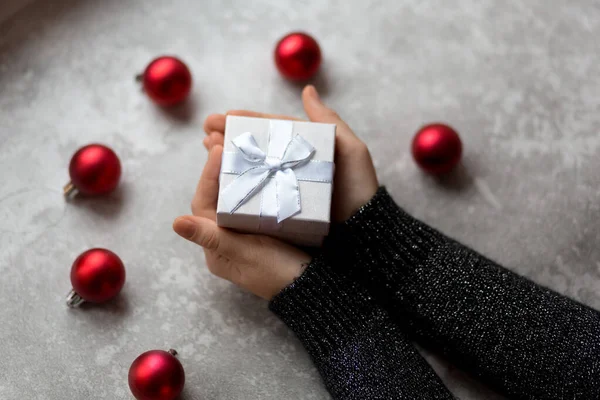 Les mains de la femme tiennent une boîte-cadeau texturée artisanale avec ruban — Photo