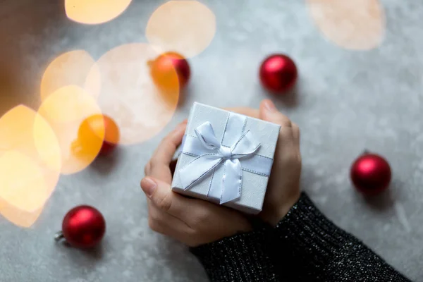 Un cadeau dans les mains d'en haut entouré de jouets de Noël vue — Photo