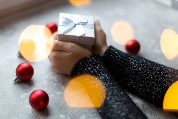 Las manos de la mujer sostienen una caja de regalo con textura artesanal con cinta —  Fotos de Stock