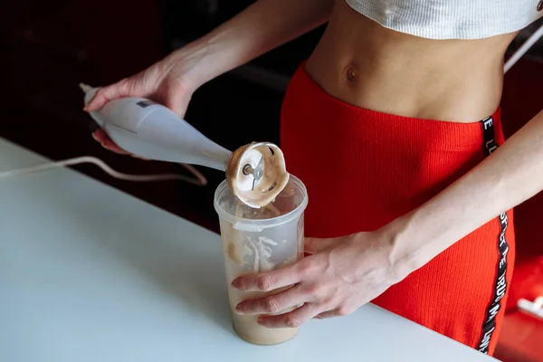 Sağlıklı beslenme, yemek pişirme, vejetaryen yiyecekler, diyet ve insanların konsepti - evde meyve suyu için blender tutan kadınlara yakın çekim.