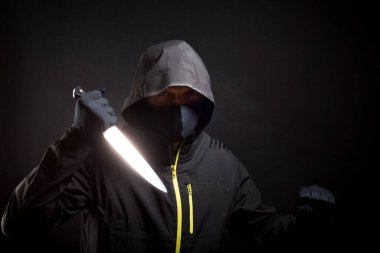 Siyahlı katil bıçağı agresif bir şekilde tutuyor. Seçici odak.