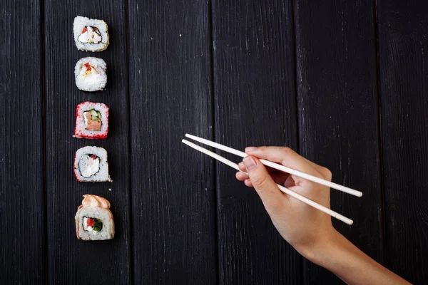 Kvinnlig Hand Tar Ätpinnar Sushi Rullar Med Kinesiska Ätpinnar Ligger — Stockfoto