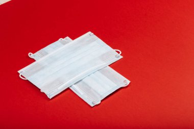 Sağlık, ilaç ve yardım konsepti: COVID-19 'dan korunmak için iki beyaz cerrahi maskeden haç.