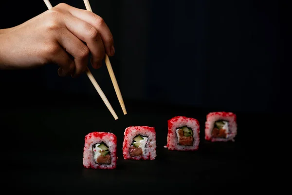 Mão Feminina Leva Pauzinhos Sushi Califórnia Rolos Com Pauzinhos Chineses — Fotografia de Stock