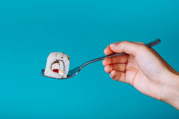 Mão Segurando Rolo Sushi Fresco Com Garfo Isolado Fundo Azul — Fotografia de Stock