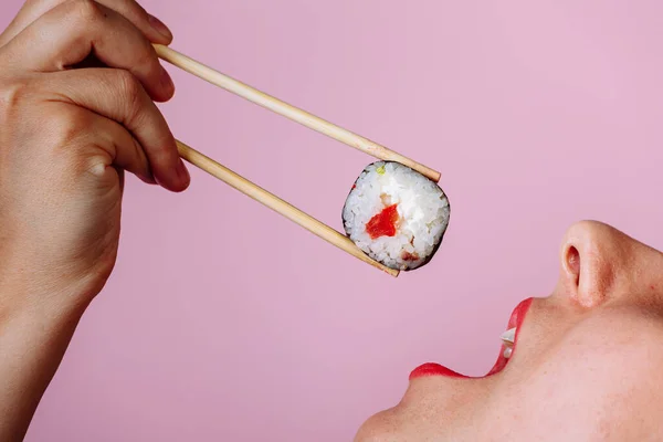 Feche macro de lábios com o rolo de Sushi. Senhora comer comida japonesa — Fotografia de Stock