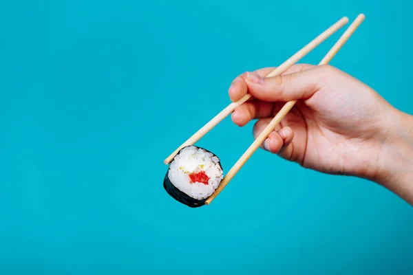 Mano Mujer Sostiene Sabroso Maki Rollo Sushi Con Palillos Madera —  Fotos de Stock