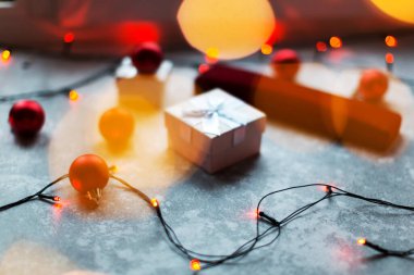 Noel baloları ve beyaz vinli hediye kutuları Noel ağacının süslemesini oluşturur. Arka planda bir bokeh şeklinde renkli ışıklar görebilirsiniz. Tatil sezonunun tipik ışıkları...