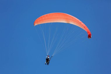 Kırmızı Paraglider güneşli bir günde bulutlarla gökyüzüne uçuyor..