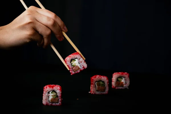 Mão Feminina Leva Pauzinhos Sushi Califórnia Rolos Com Pauzinhos Chineses — Fotografia de Stock