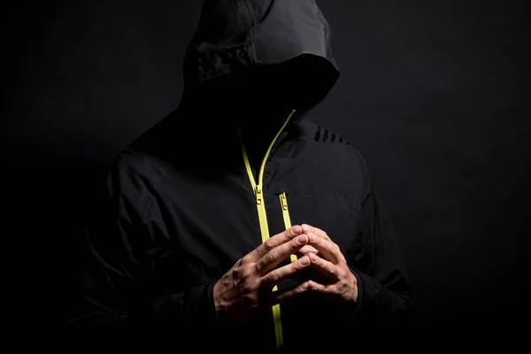 Portrait of Invisible man hacker in the hood isolated on black background.