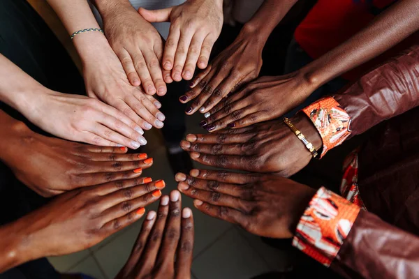 Hands of happy group of African Latin American and European people which stay together in circle happy